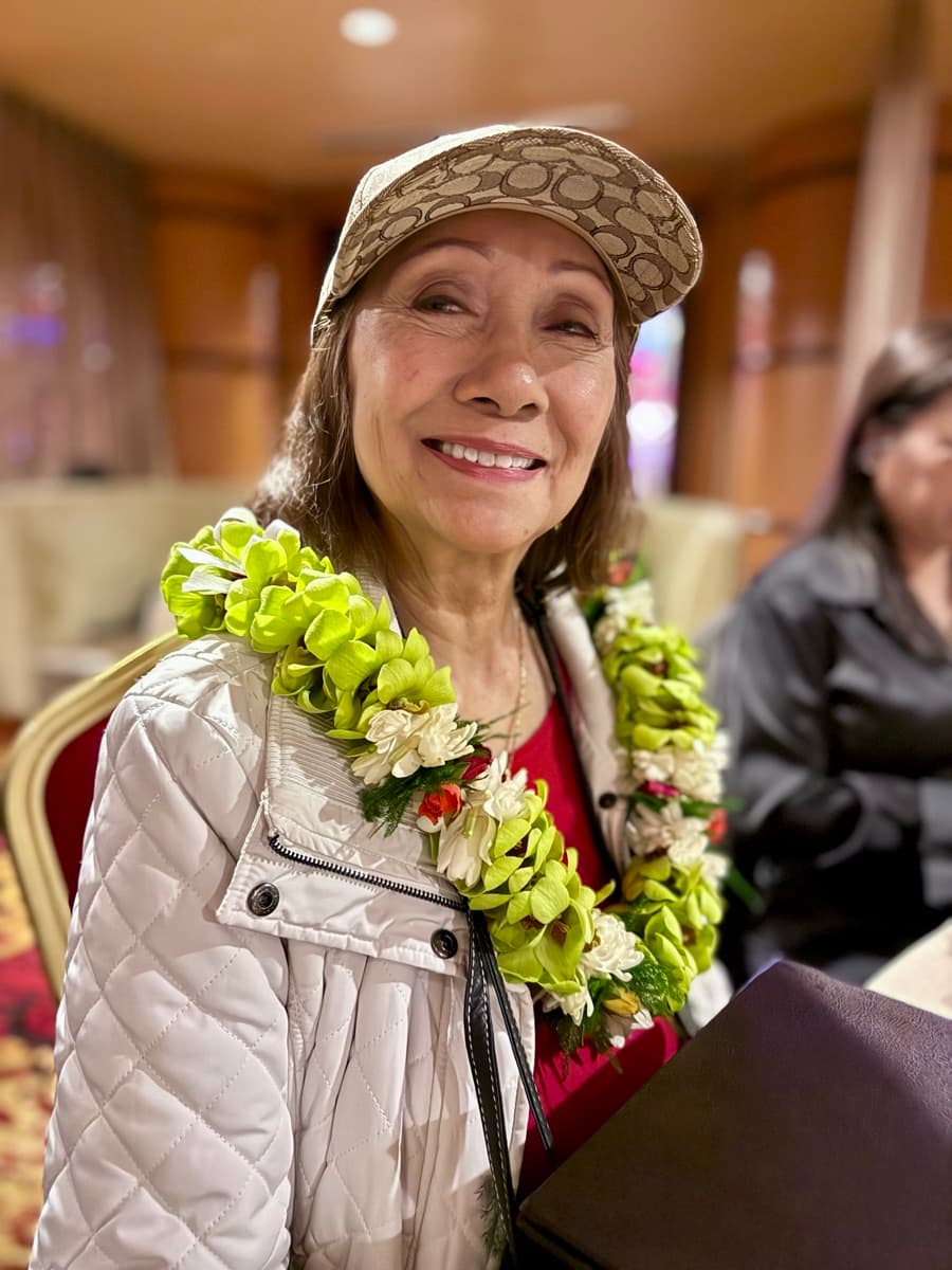 My mom, smiling, wearing a flower lei.
